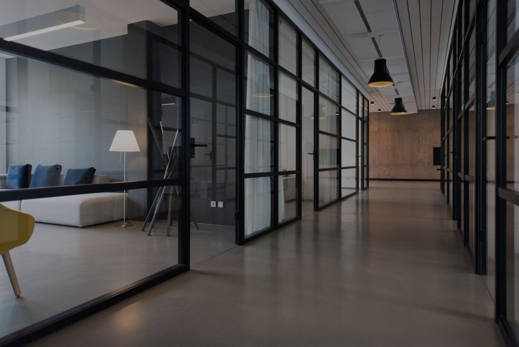 A modern office space hallway with offices on each side